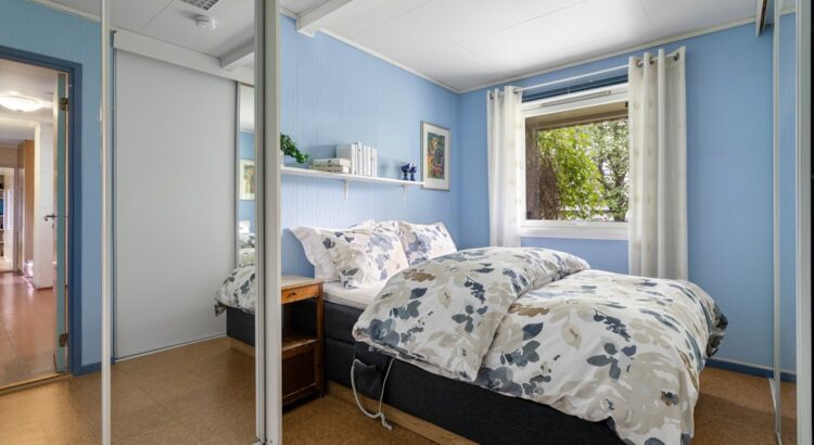 A bedroom with blue walls and a bed